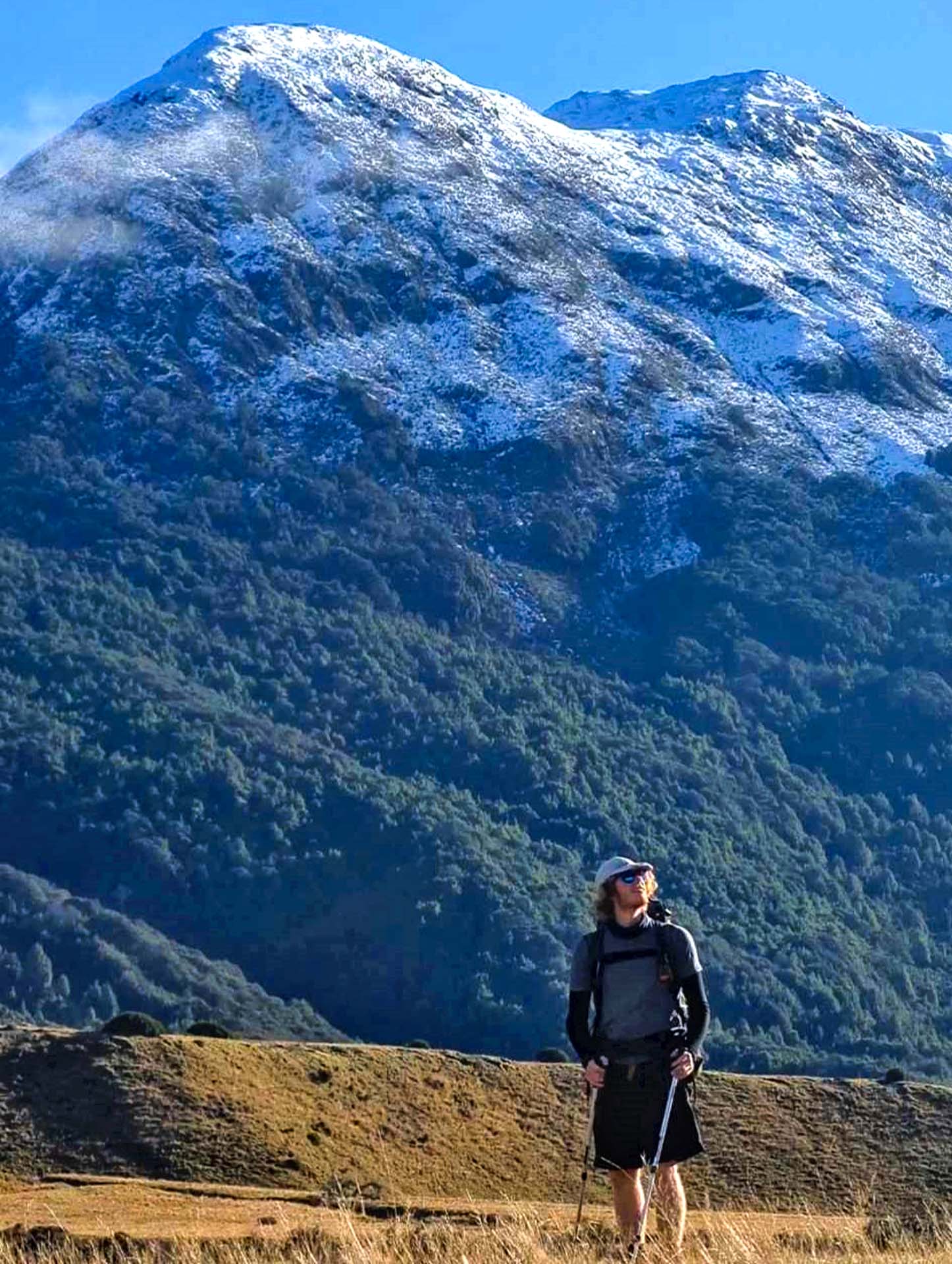 The Greenstone-Caples Track Is The Most Dynamic Hike in New Zealand, Photo by Lachlan Pearce, multi-day hike, new zealand hike, alpine hiking, back country hiking, hiker posing in front of mountain in the greenstone valley