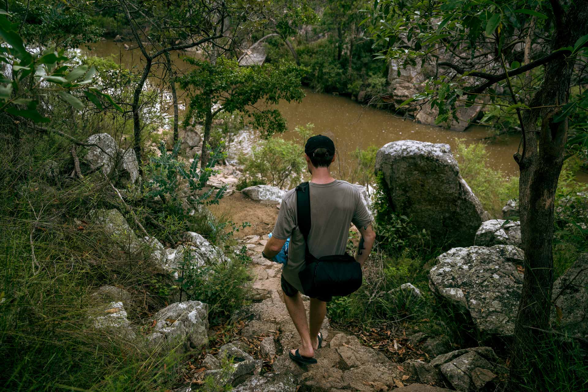 6 Queensland Country Pubs, Bars, & Distilleries with Adventures Nearby, Photo by Rian Cope, queensland, southern queensland country, sponsored, man hiking down to rock poool in crows nest falls