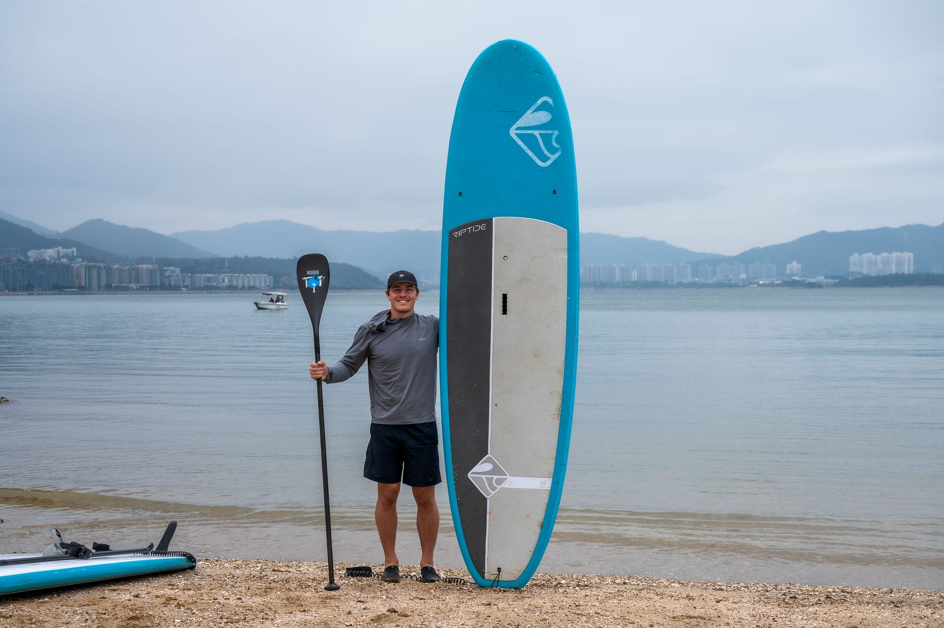 Mountains, Islands, and Deserted Beaches: Travel Hong Kong Like an Explorer , Photo by Cam Bostock, hong kong, international, travel guide, cam bostock standing next tot stand up paddle board on the sham chung tour