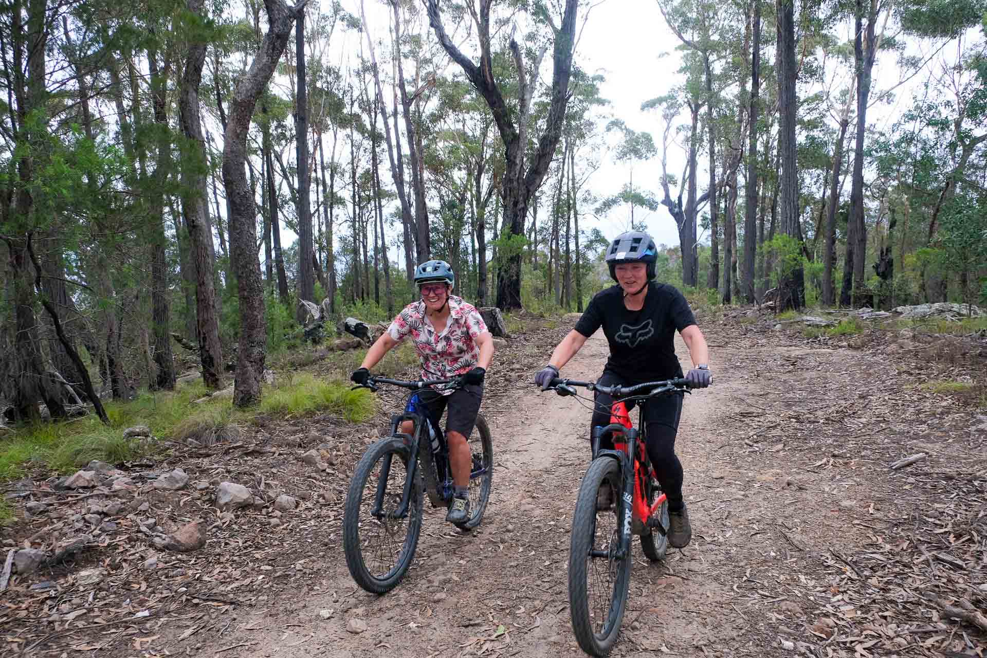 Gravity Eden – Dirt Surfing at NSW South Coast’s Newest Mountain Bike Park, Photo by Sarah Pendergrass, cycling, mountain biking, gravel biking, two cyclists smiling while riding