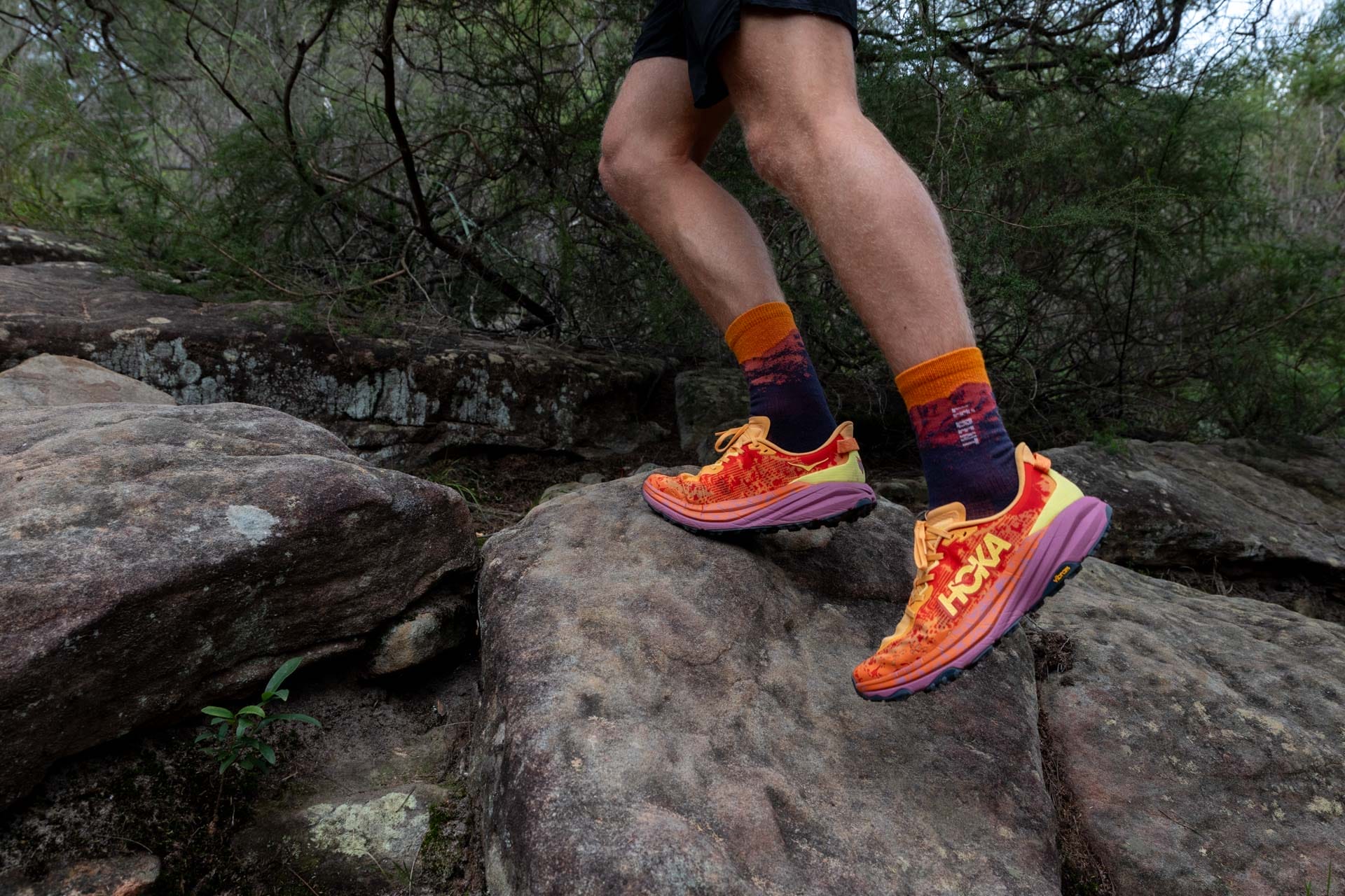 Hoka's Speedgoat 6 Will Have You Trail Running in Technicolour, Photo by Matt Wiseman, first look, pair of trail runners, man running over rock