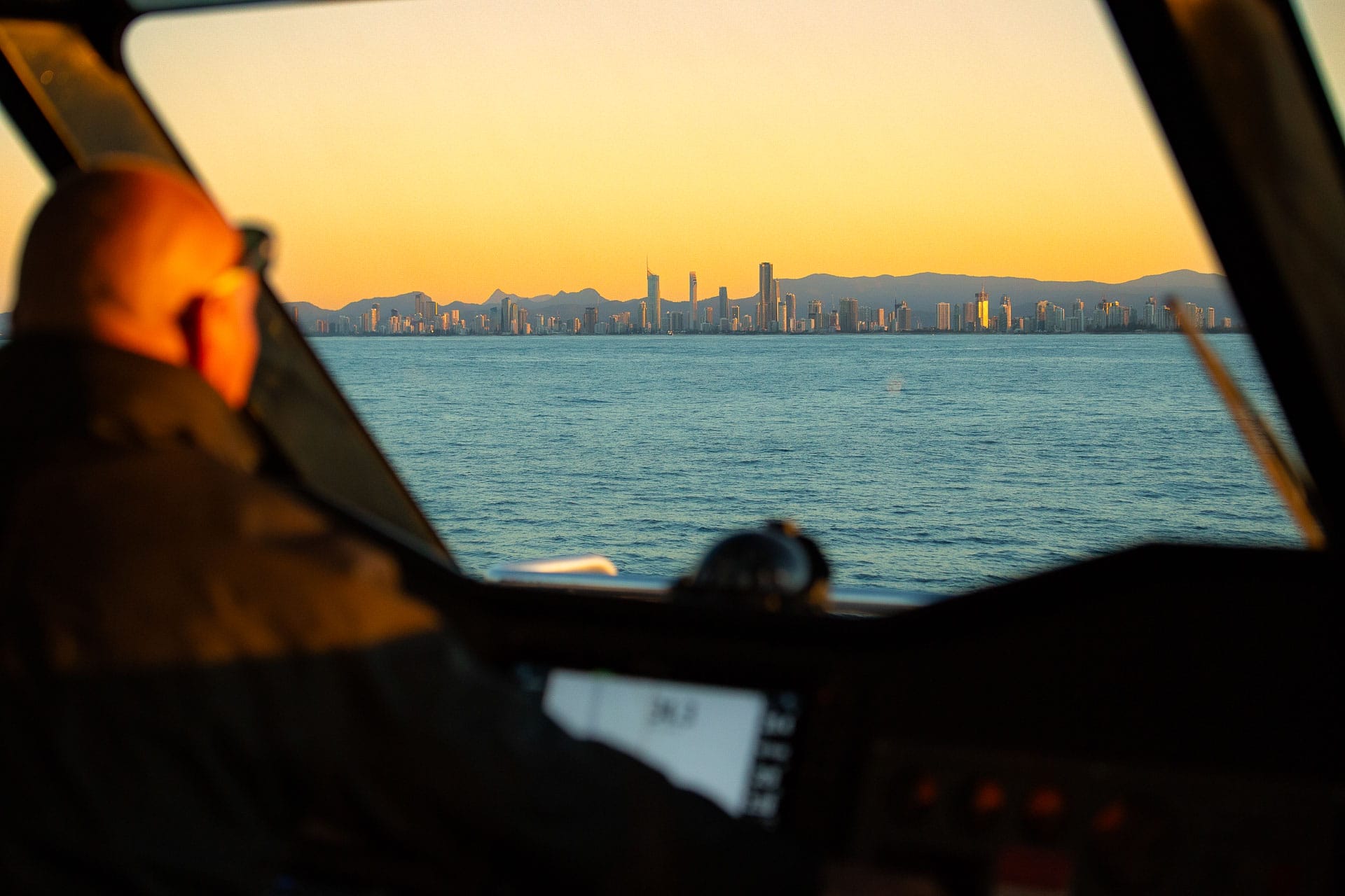 Captain Wayne steers the boat home at sunset, overlooking Surfer_s Paradise, 6 Things I Learnt on a Gold Coast Whale Watching Tour, Casey Fung, Destination Gold Coast, sea world whale watching, queensland