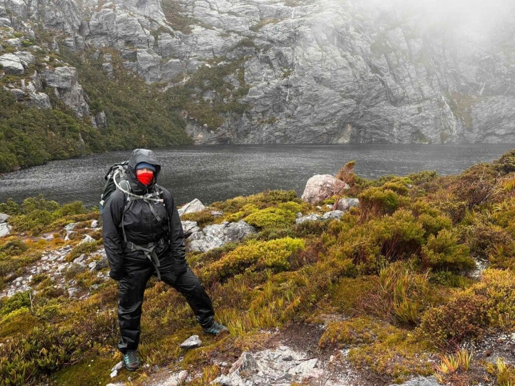 Western Arthurs Traverse, Tasmania, Square Lake, Lake Oberon, by Mat Young, hiker, rain gear, backpack, mountain lake, foggy, rugged terrain, cold weather, remote wilderness, challenging multi-day hike