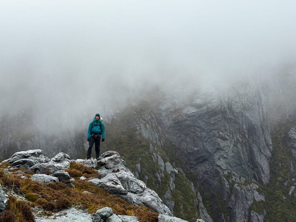 Western Arthurs Traverse, Tasmania, mountain guide Mat Young, hiker, rocky landscape, dense fog, misty mountains, steep cliffs, cold weather, multi-day hike, challenging terrain, remote wilderness