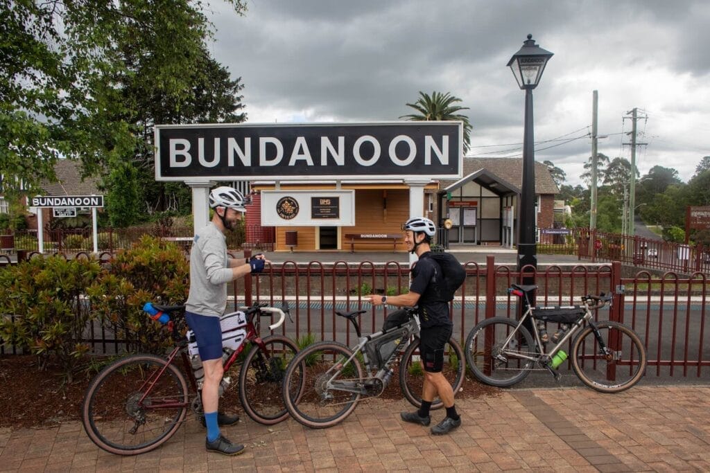 Bundanoon train station, Attack of the Buns bikepacking route, by Mattie J Gould, two cyclists, gravel bikes, bikepacking, finish line, Southern Highlands NSW, cloudy sky