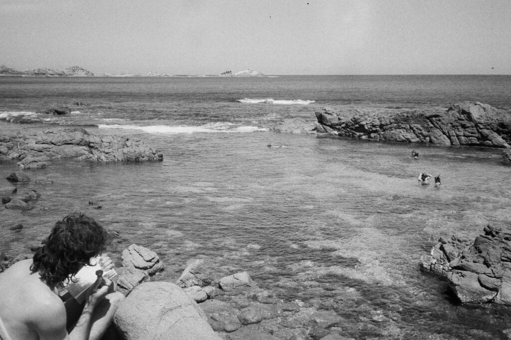 Redgate Beach, Western Australia, by Reece Johnston, rocky coastline, clear ocean, swimmers, black and white film photography, travel, nature