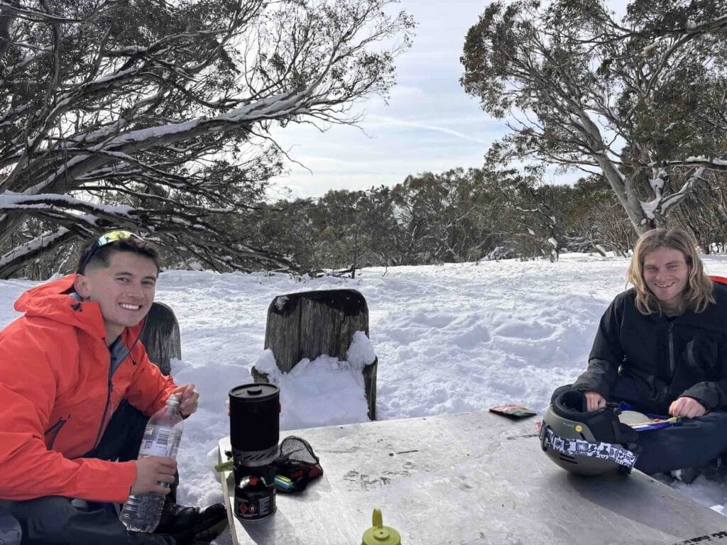 Mt Stirling, Victoria, Australia, snowy backcountry, outdoor meal break, portable stove, two men, smiling, winter landscape, ski touring