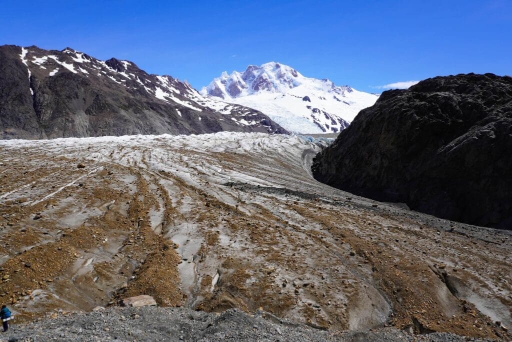Huemul Trek Glacier, Patagonia, by Hayley, moraine landscape, snow-capped mountains, clear blue sky, Los Glaciares National Park, Argentina