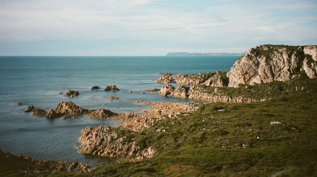 Coastal landscape, Ruby Amble, rocky cliffs, blue ocean, green bushland, adventure reflection