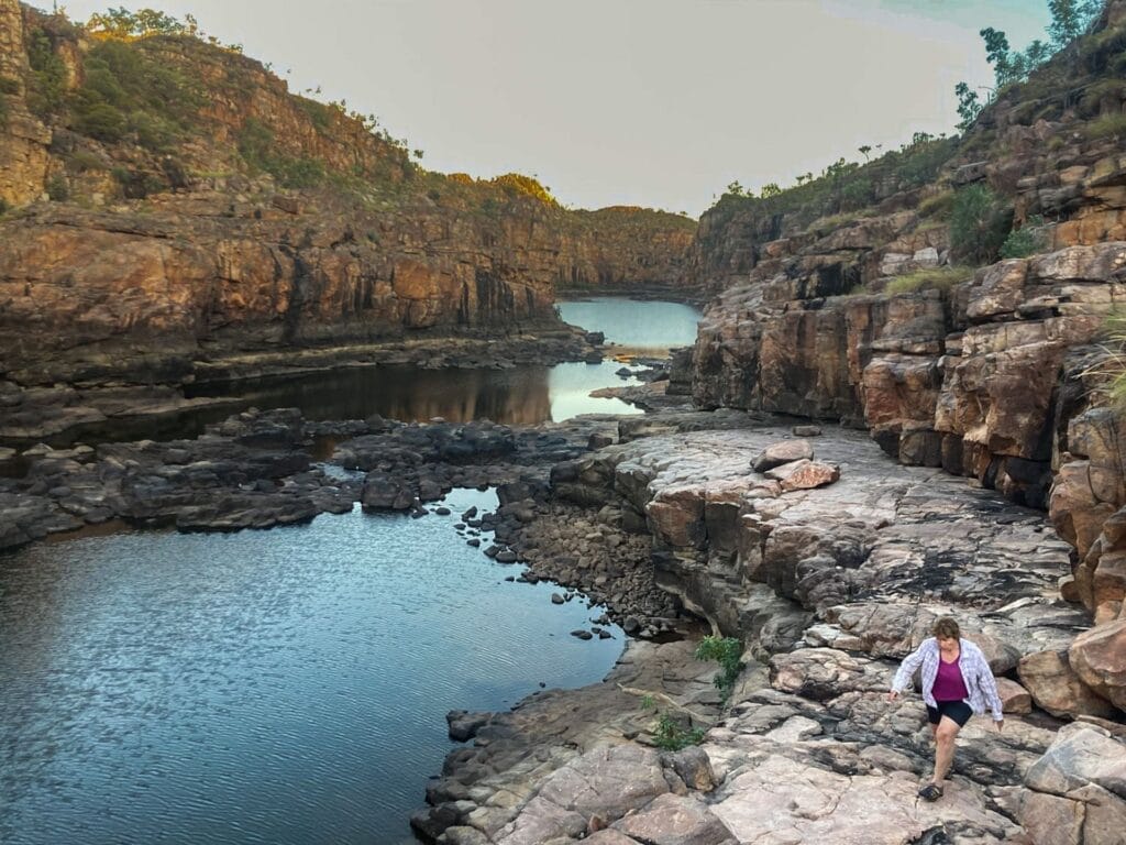 Nitmiluk Gorge, Northern Territory, Australia, by Andrea Salus, woman hiking, rocky path, river, rugged landscape, cliffs, adventure