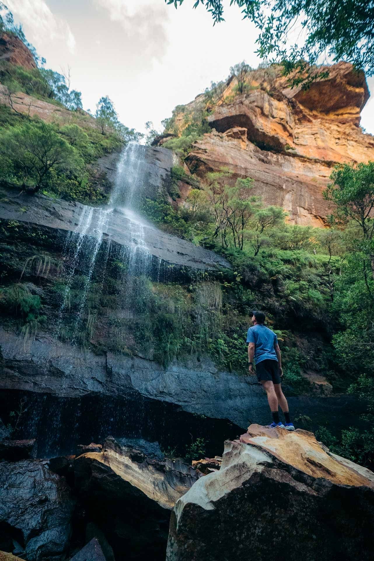 Blue Mountains waterfall, Tim at waterfall, by Paul, rocky cliffs, lush greenery, outdoor adventure, hiking, We Are Explorers