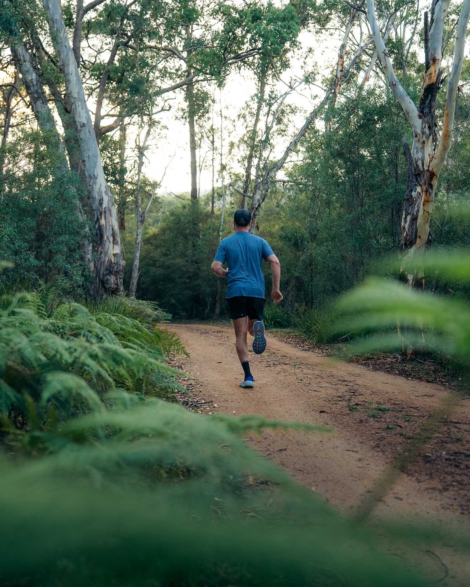 Tim running, by Paul, forest trail, Australian bush, outdoor adventure, green foliage, We Are Explorers