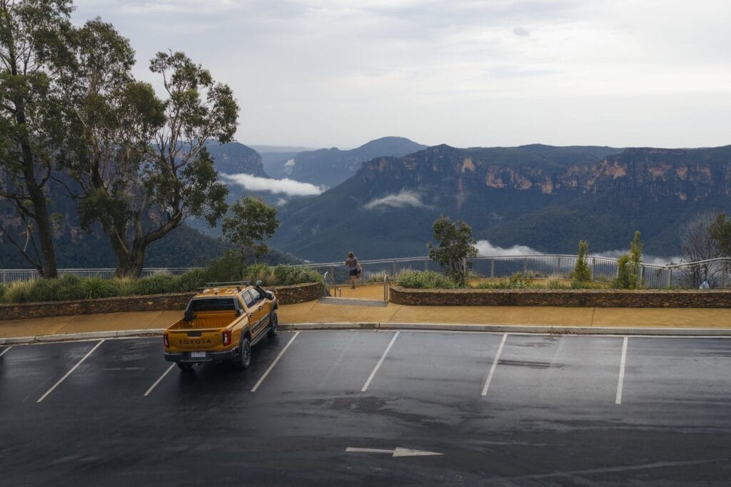 Blue Mountains Australia, Daygin, Toyota HiLux pickup truck, mountain lookout, wet parking lot, person, misty valley, cloudy landscape, Sublime Point, Dharug and Gundungurra Country, adventure photography