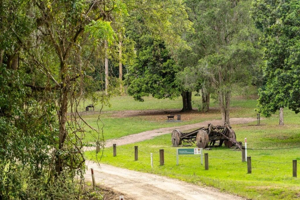 Gloucester River Campground, Barrington Tops National Park NSW, dirt track, grassy area, forest, old logging machinery, wooden wheels, picnic area, walking trail, peaceful scenery, camping, nature, historical relics
