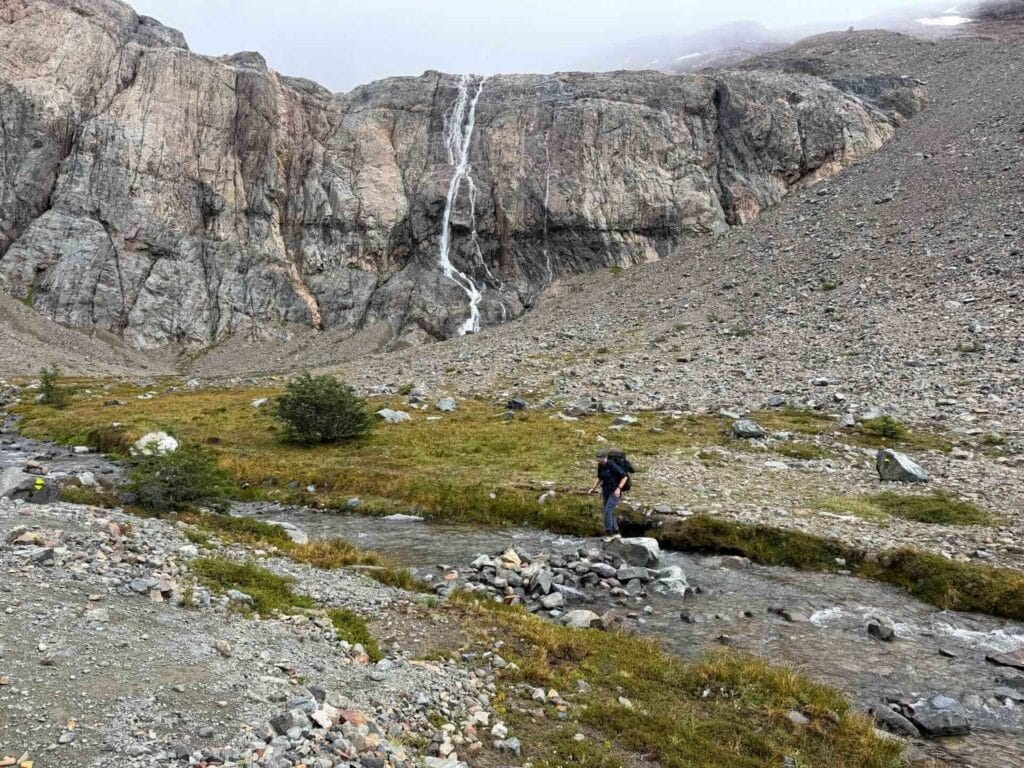 Cerro Castillo National Park, Patagonia, Las Horquetas Trek, hiker, river crossing, stream, rocky mountain, waterfall, rugged landscape, hiking