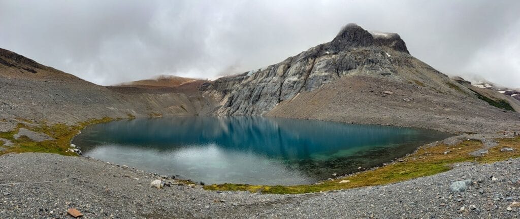 Laguna Cerro Castillo, by Bea, Cerro Castillo National Park, Patagonia, turquoise glacial lake, rocky mountains, overcast sky, glacier, Las Horquetas Trek, serene landscape, reflection