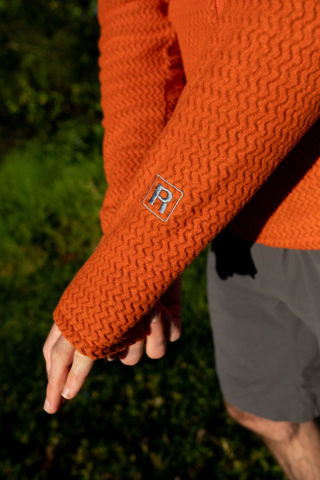 Why Every Explorer Needs a Technical Fleece Like This One, photo by Ella Garbett, model Lachie Hand, R1 Air fleece, orange, sleeve