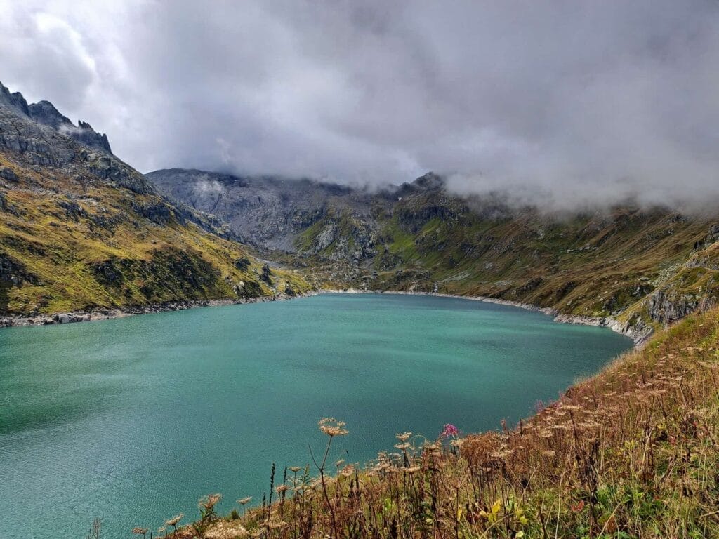 Lago di Lucendro, by Beckerhoff, Airolo Region, Swiss alpine lake, turquoise water, cloudy mountains, rocky slopes, hiking trails, Switzerland